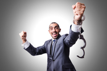 Funny businessman with handcuffs on white