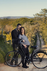 Close up view of a expecting happy couple on a bicycle.