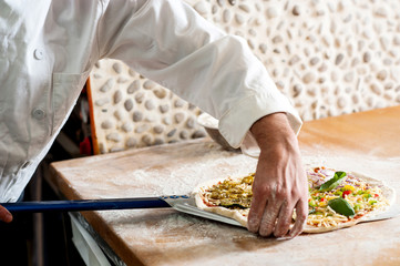 Chef taking pizza dough to cook