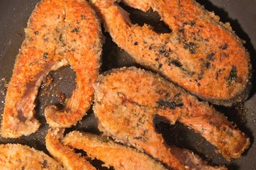 fried breaded fish steak in a frying pan