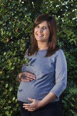 Close up view of a expecting pregnant happy woman on the garden.
