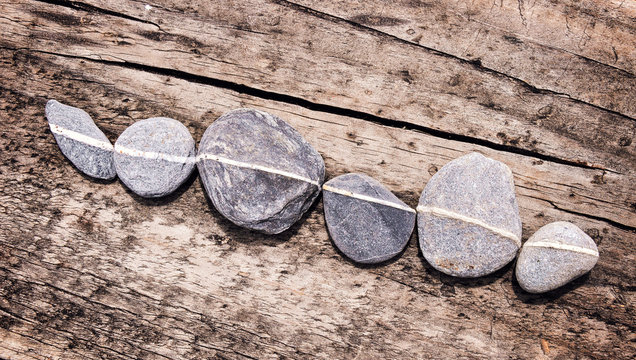 Lign of stones on a wooden background