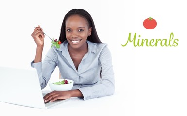 Minerals against joyful businesswoman working with a laptop