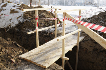 Wooden bridge over dug trench.