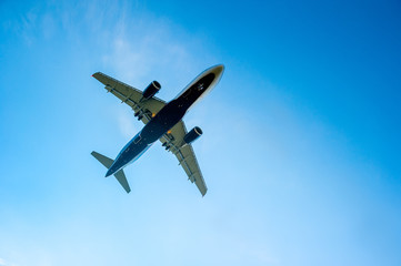 airplane in the blue cloudless sky is landing