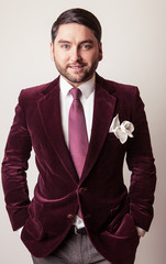 Elegant young handsome man in luxury velvet claret costume. 