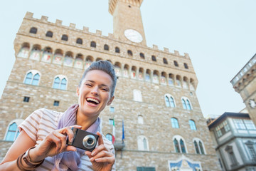 Portrait of happy young woman with photo camera in firenze