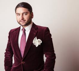 Elegant young handsome man in luxury velvet claret costume. 