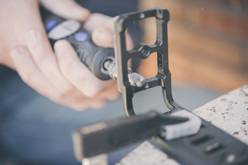 Sanding a miniature figure in the clutch with a dremel machine