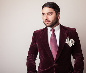 Elegant young handsome man in luxury velvet claret costume. 