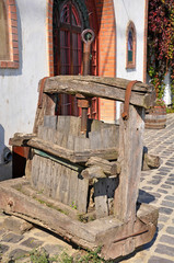 Old wooden wine press next to a cellar building