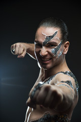 Young handsome man with mosaic body art painting