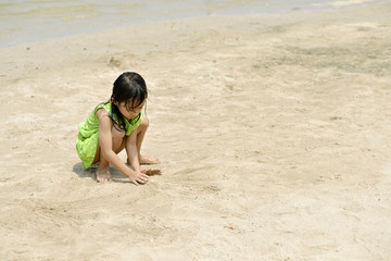 Asian girl playing on the beach in the summertime