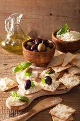 crackers with soft cheese and olives. healthy appetizer