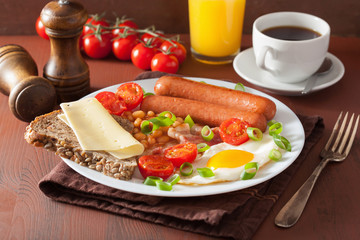 Fototapeta na wymiar english breakfast with fried egg sausages bacon tomatoes beans