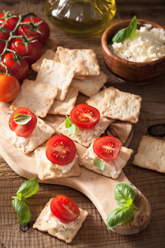 crackers with soft cheese and tomatoes. healthy appetizer