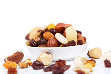 Mixed nuts and sultanas on a plate on a white background