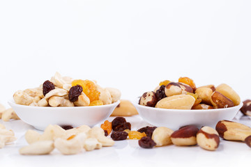 Fototapeta na wymiar Mixed nuts and sultanas on a plate on a white background