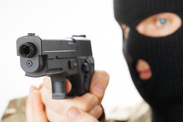 Man in black mask holding gun in front of him
