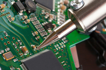 Soldering iron and microcircuit - closeup studio shot