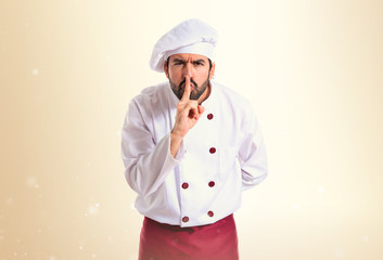 Chef making silence gesture over white background