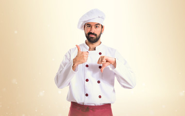 Chef making a good-bad sign over white background