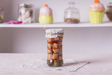 a small glass jar with conservation, corn, peppers, mushrooms