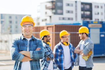 group of smiling builders in hardhats outdoors