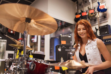 smiling musician playing cymbals at music store