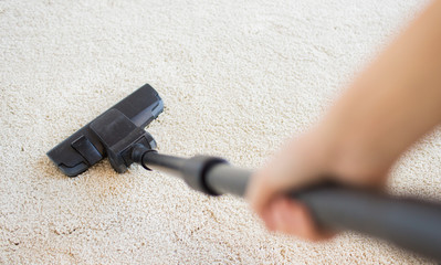 close up of hand with vacuum cleaner at home