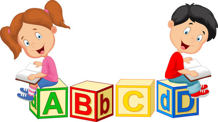 Children reading book and sitting on alphabet blocks