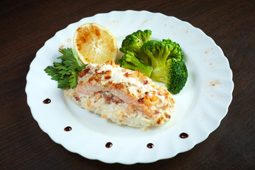 Serving of tasty baked fish with vegetables