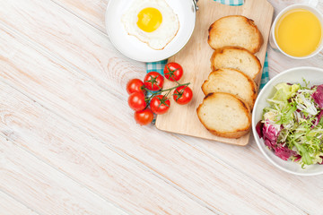Healthy breakfast with fried egg, toasts and salad