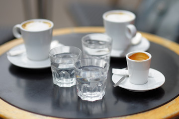 Fototapeta na wymiar Three cups of fresh coffee on table of street cafe
