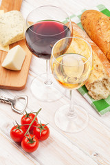 White and red wine glasses, cheese and bread