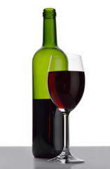 Bottle and wineglass with red wine.