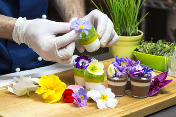 Obraz na płótnie Canvas cook prepares canapes dessert edible flowers and buds