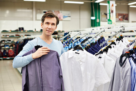 Man chooses shirt in shop