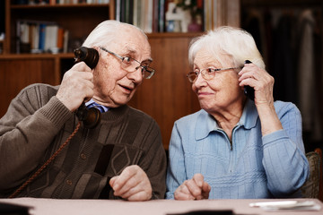 Senior couple with old telephone and smartphone