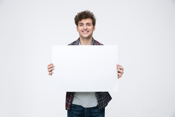 Happy man with curly hair holding blank billboard