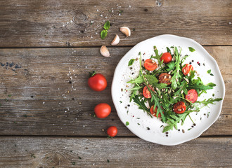 Salad with arugula, cherry tomatoes, sunflower seeds and herbs