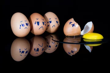 Foto op Plexiglas Broken egg on shiny black surface with friends being sad © Alta Oosthuizen