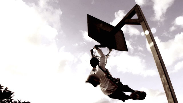 Basketball player dunking basketball and scores in basket