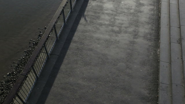 Runner on embankment under millenium bridge, London, UK