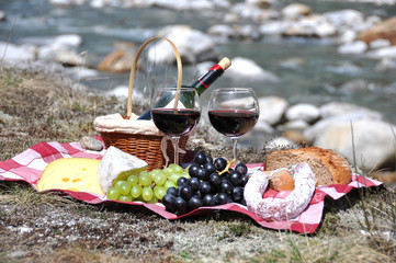 Red wine, cheese and grapes served at a picnic. Verzasca valley,