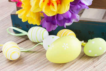 easter eggs and posy  of spring flowers on wooden table