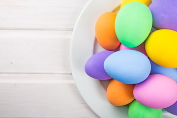 Colorful pastel easter eggs on white wooden background