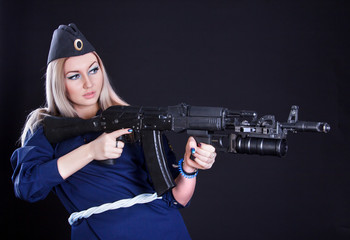 Beautiful young woman in a marine uniform with an assault rifle