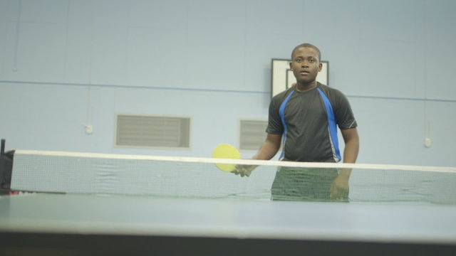 Boy playing table tennis in gym
