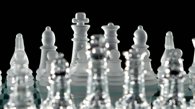 Chess pieces is standing on glass  board. Close up